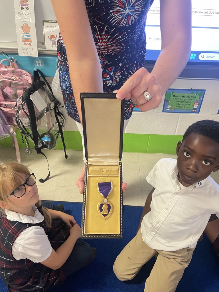 Pictures of first graders during the discussion about a student's great grandfather earning a Purple Heart in WWII.