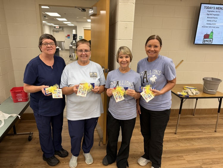 4 cafeteria ladies posing with their school lunch hero day treat 
