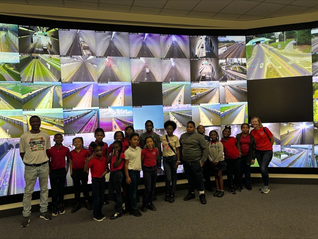 A group of students from Morningside Elementary standing in front of tv monitors for the Bankhead tunnel .