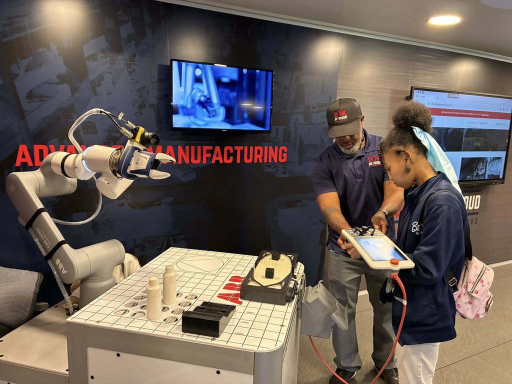A student and Be Pro Be Proud Alabama volunteer exploring advanced manufacturing equipment. 