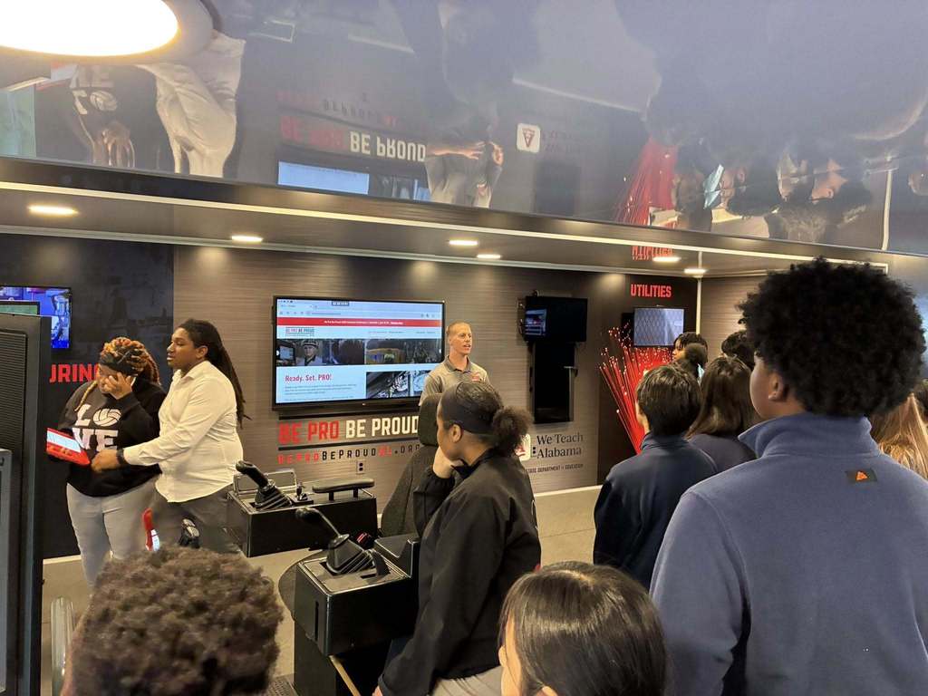 Students listening to a presentation in the Be Pro Be Proud Alabama Truck. 