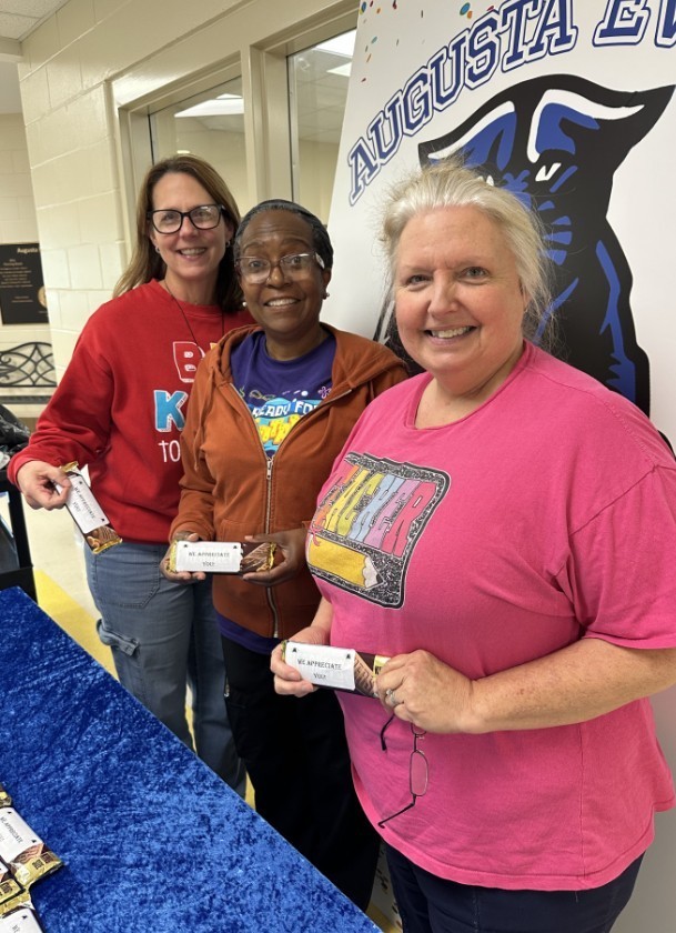 Group Jag level teachers and para holding the candy bar in front of the teacher appreciation sign 
