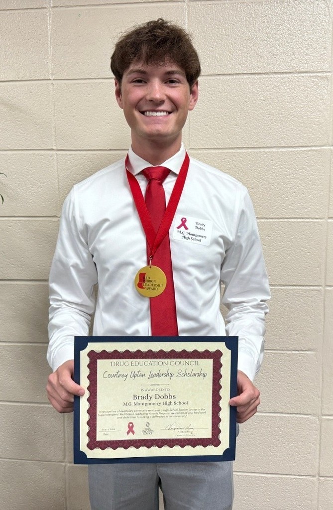 Brady Dobbs wearing a medal and holding a certificate