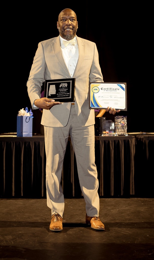 Chresal D. Threadgill holds two plaques from the PTA