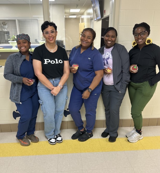 Mrs. Kidd and nurses with a group photo holding their cupcakes 