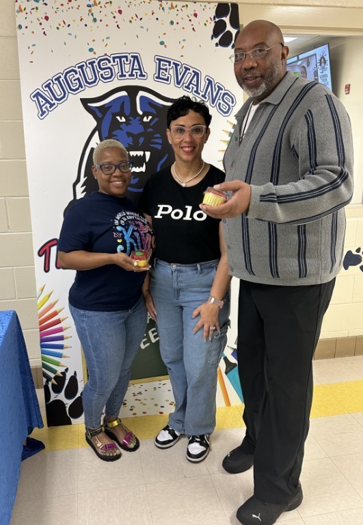 Mrs. Kidd with a para and behavior trainer holding their cupcakes 