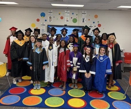 A group of seniors in caps and gowns at Old Shell Road magnet