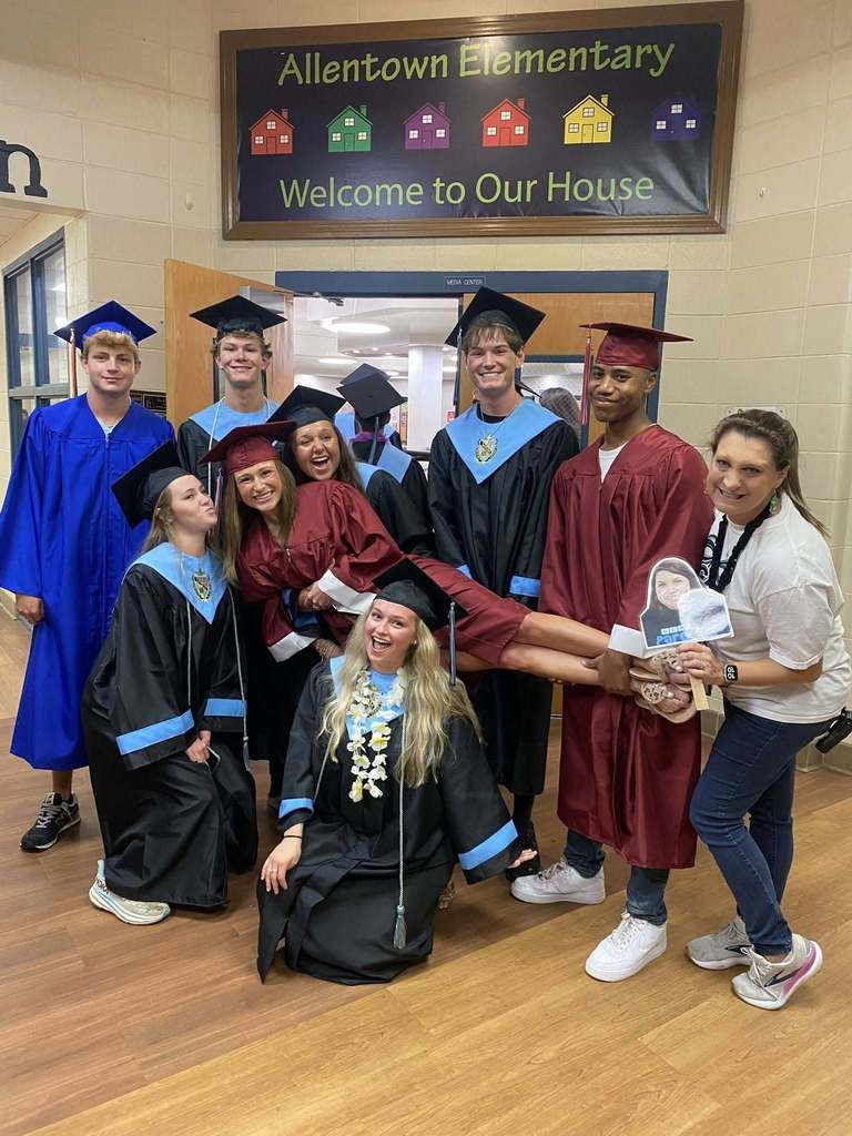 Seniors in caps and gowns holding another senior off the floor at Allentown Elementary