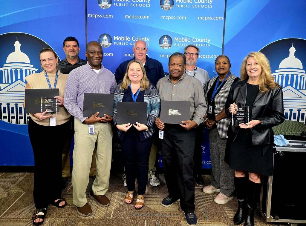 A group of MCPSS communications employees holding certificates
