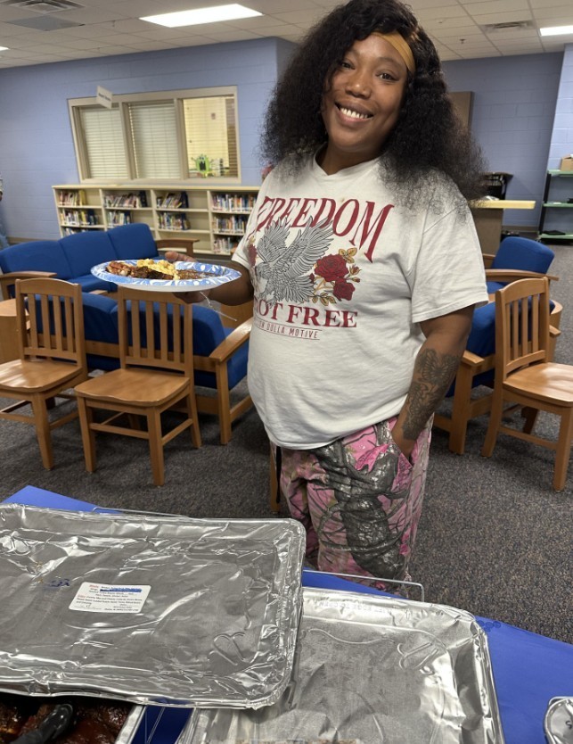 Sensory Room teacher smiling with her plate of food 