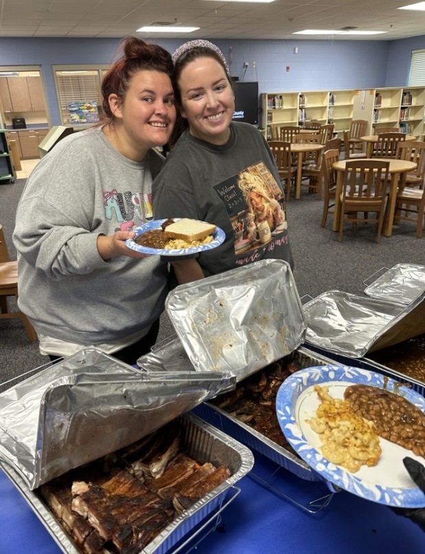 Two teachers smiling with their plates of food  