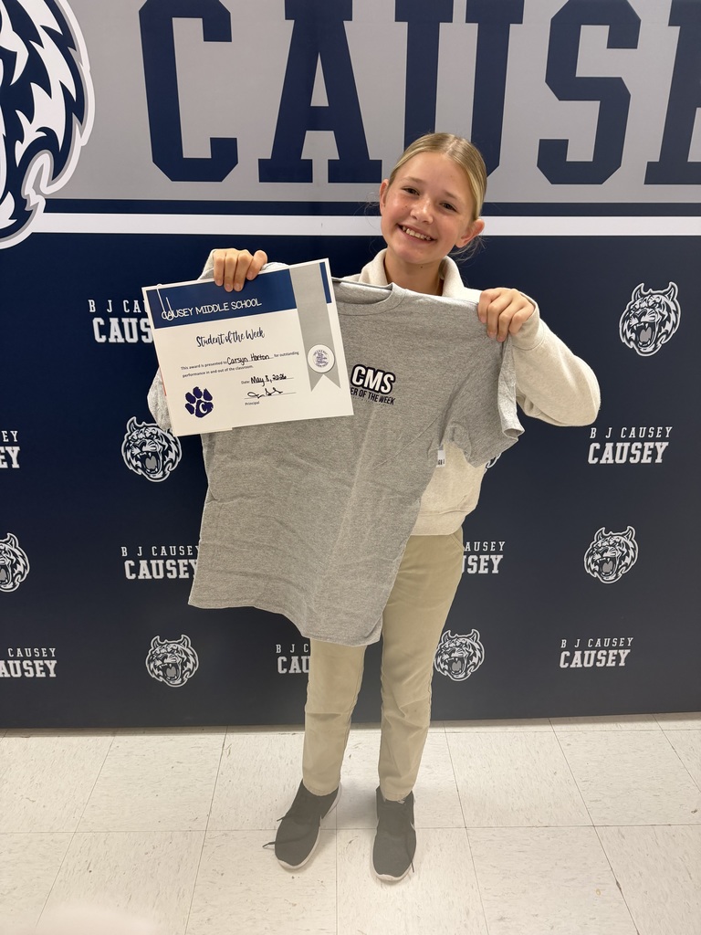 Student holding t-shirt and certificate