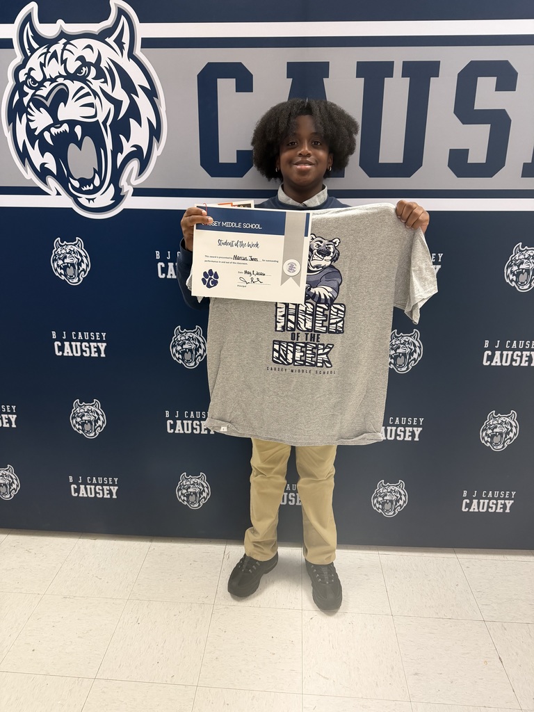 Student holding t-shirt and certificate