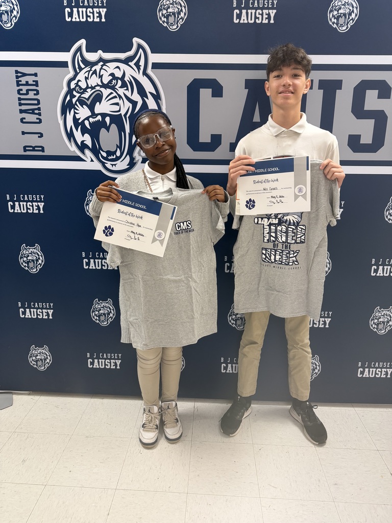 2 students holding up t-shirts and certificates