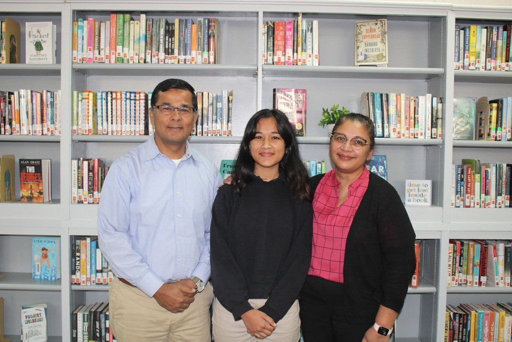 Sariah Hossain stands with her parents in the school library