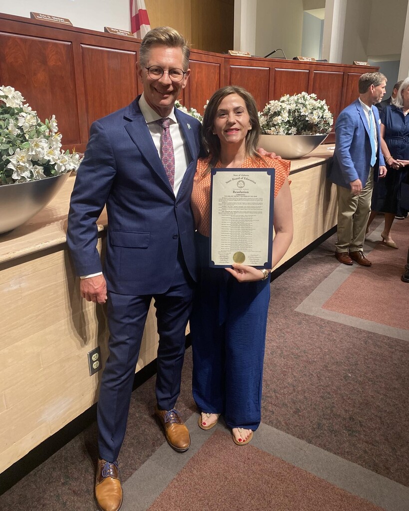 Jennifer Asberry holds a certificate while standing with Dr. Eric Mackey