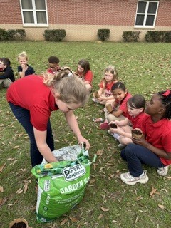 Ms. Thorntons First Grade engaged in a hands-on two month science project, planting zinnia seeds in March and repotting them today. This activity helped the students understand the plant life cycle, plant parts, and needs, nurturing patience and stewardship. 
