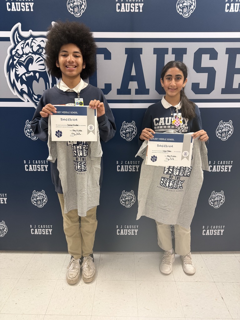 2 students holding up t-shirts and certificates