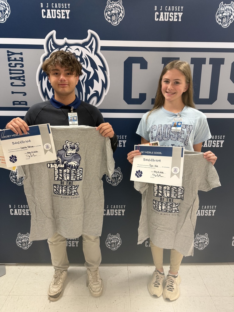 2 students holding up t-shirts and certificates