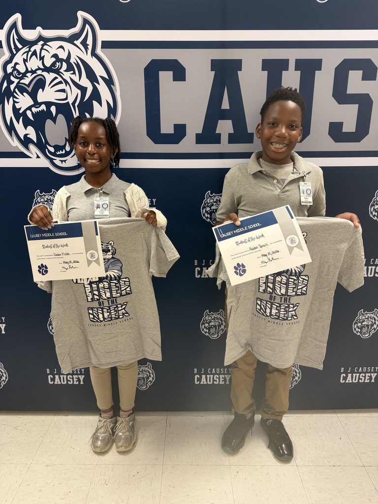 2 students holding up t-shirts and certificates