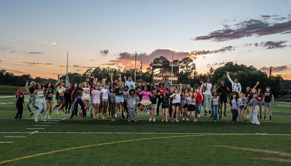 A group of Davidson students jumping on a football field