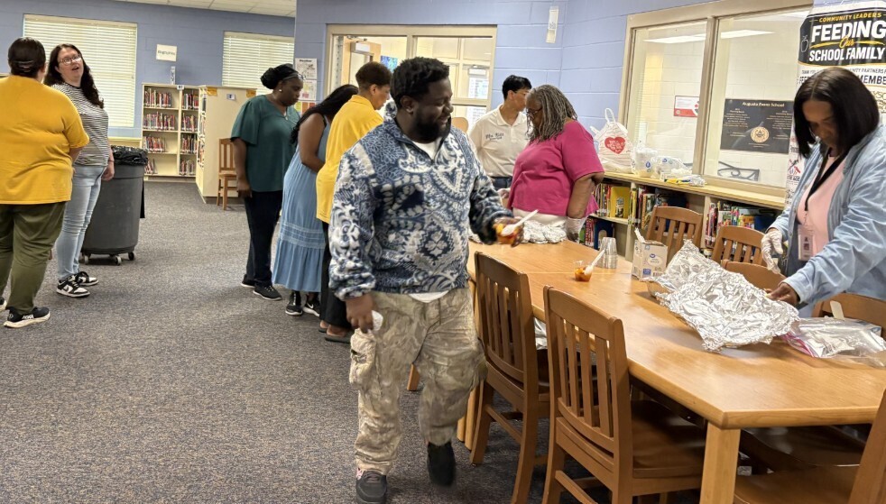 Group picture of the staff in line getting their breakfast items 