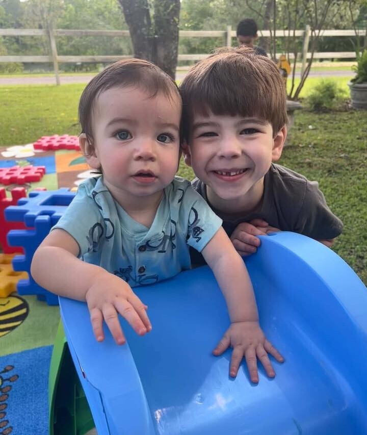 Two children play on a plastic slide