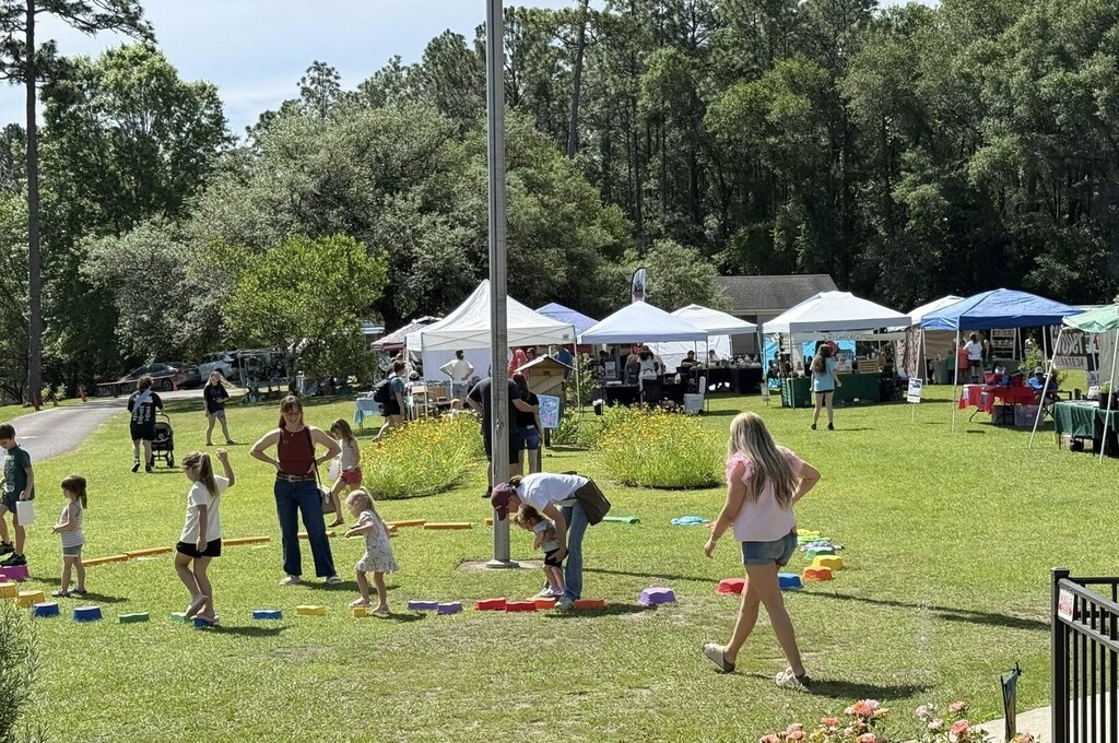 Children play on the lawn at the Environmental Studies Center, with tents in the background