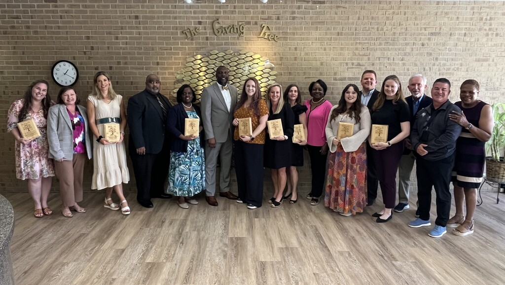 A group of teachers and principals stands with MCPSS Superintendent Chresal D. Threadgill and two school board members