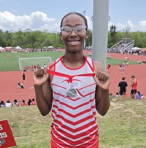 Markenzie Mills shows off her medal at the USA track complex