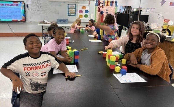 Students sitting around a table with colorful blocks