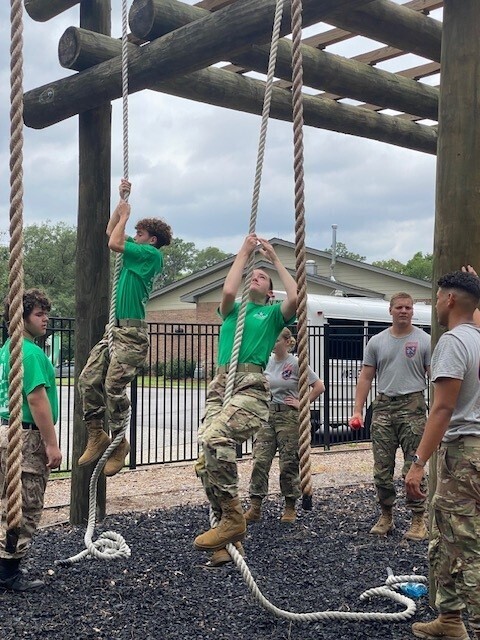 Two JROTC cadets attempt to climb ropes
