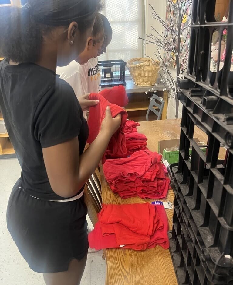 Williamson cheerleaders sorting red T-shirts