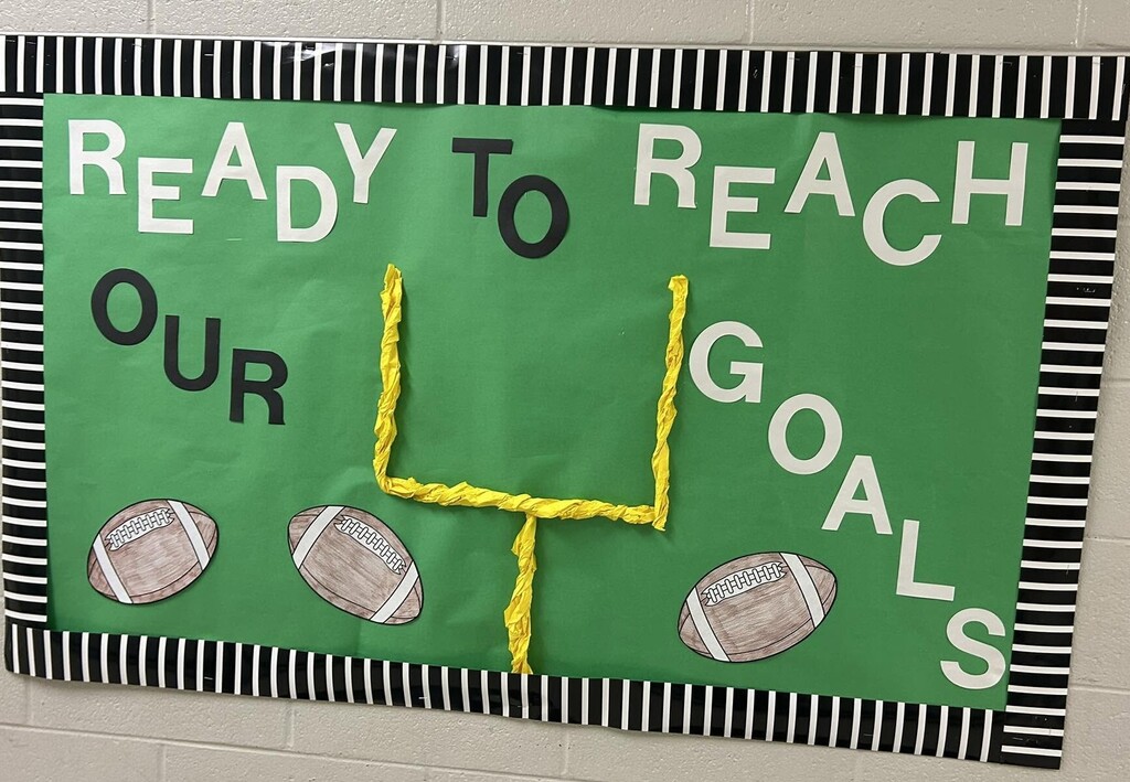A bulletin board with footballs and a goalpost and the words "Ready to Reach our Goals"