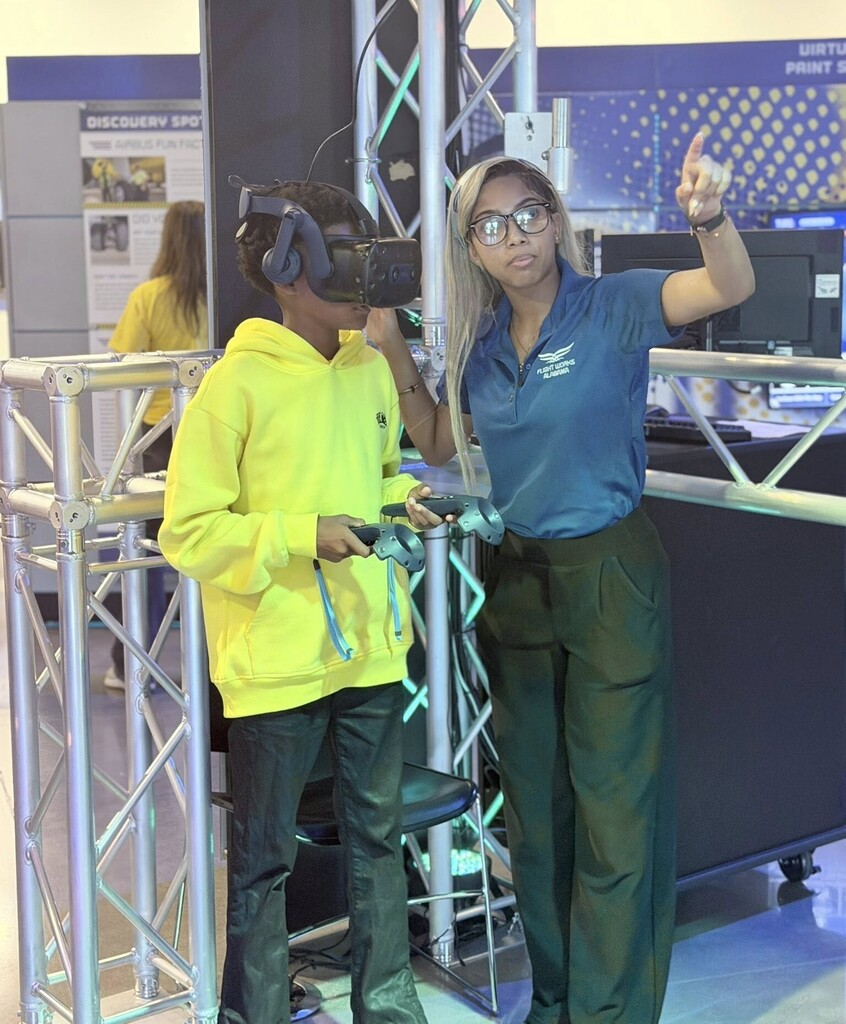 A woman talks with a boy who is in virtual reality goggles