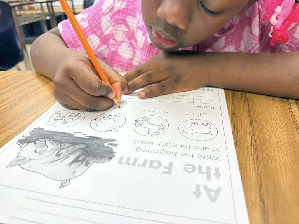 A student writes on a worksheet