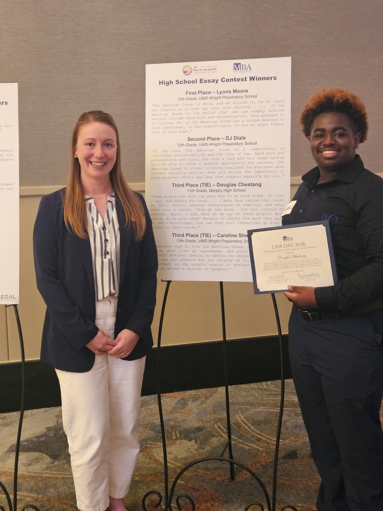 Douglas Chestang and teacher Sara Woltring stand by a placard announcing the winners of the Law Day Essay Contest