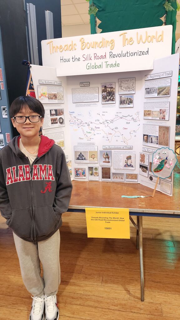 Landon Nguyen stands with his history project exhibit board