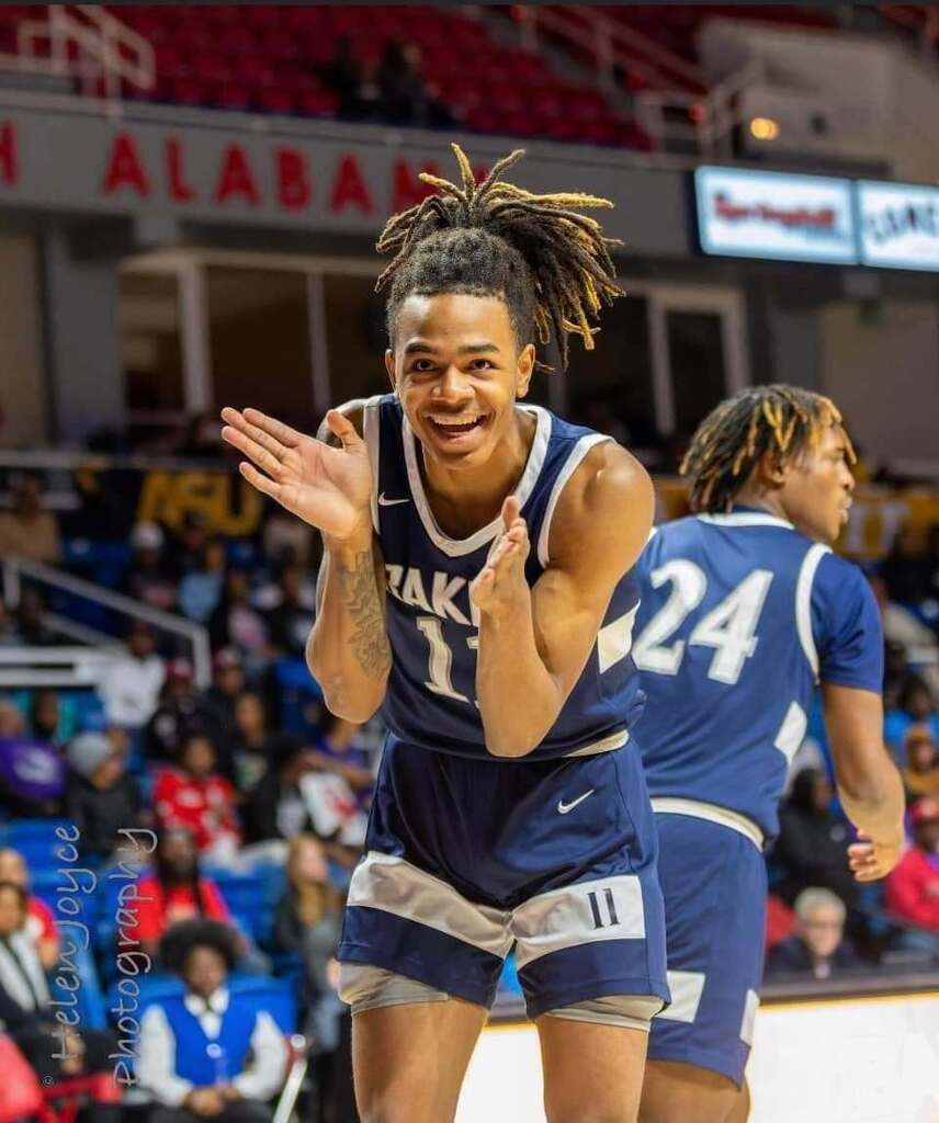 Labaron Philon claps on the court while wearing a Baker High basketball uniform