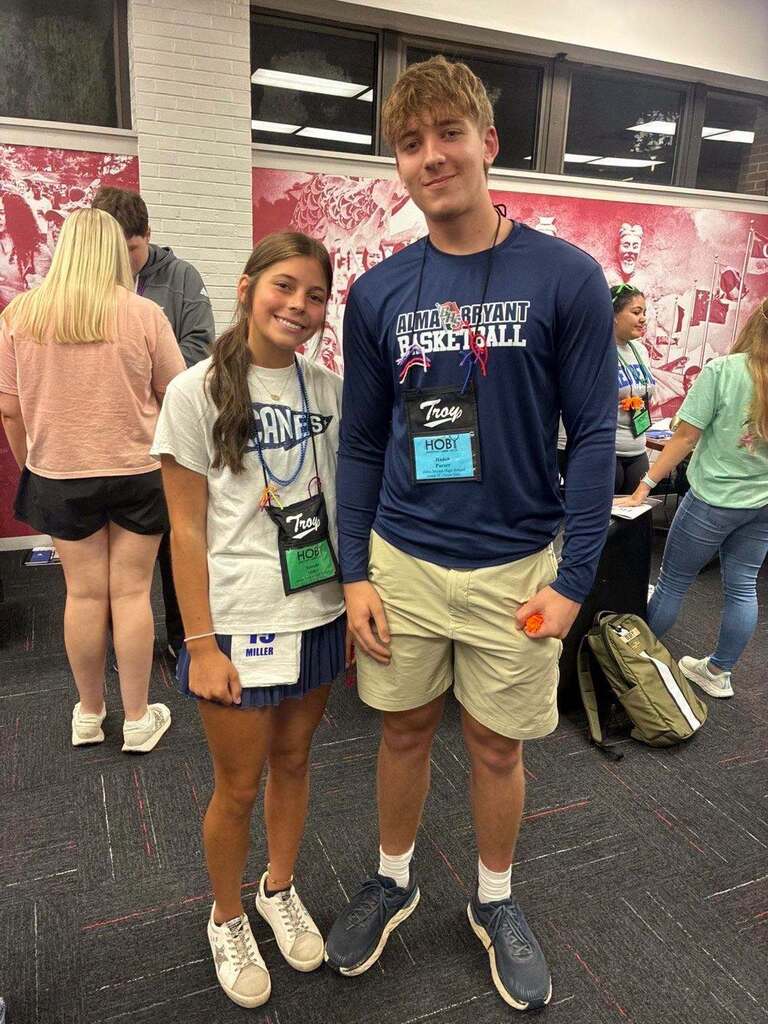 Rosalie Miller and Hayden Purser stand in a room at Troy University