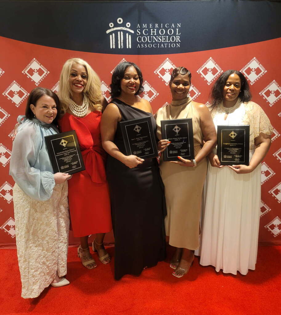 Five ladies in long dresses holding plaques