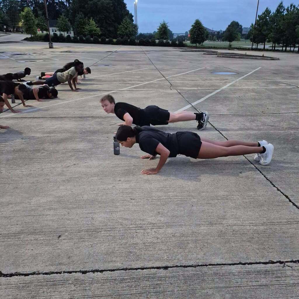 JRTOC cadets doing push-up in a parking lot