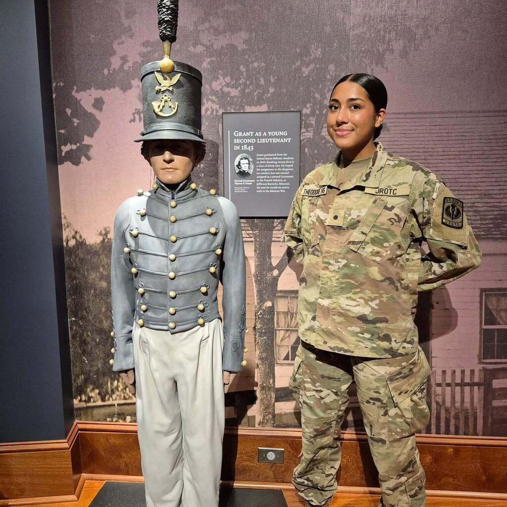 A Theodore JROTC cadet standing next to a wax figure of a young Ulysses S. Grant