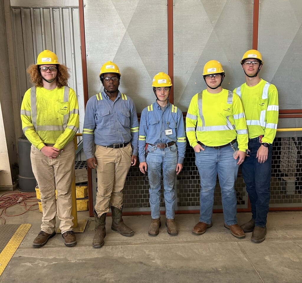 Five high school students in work clothes and hard hats