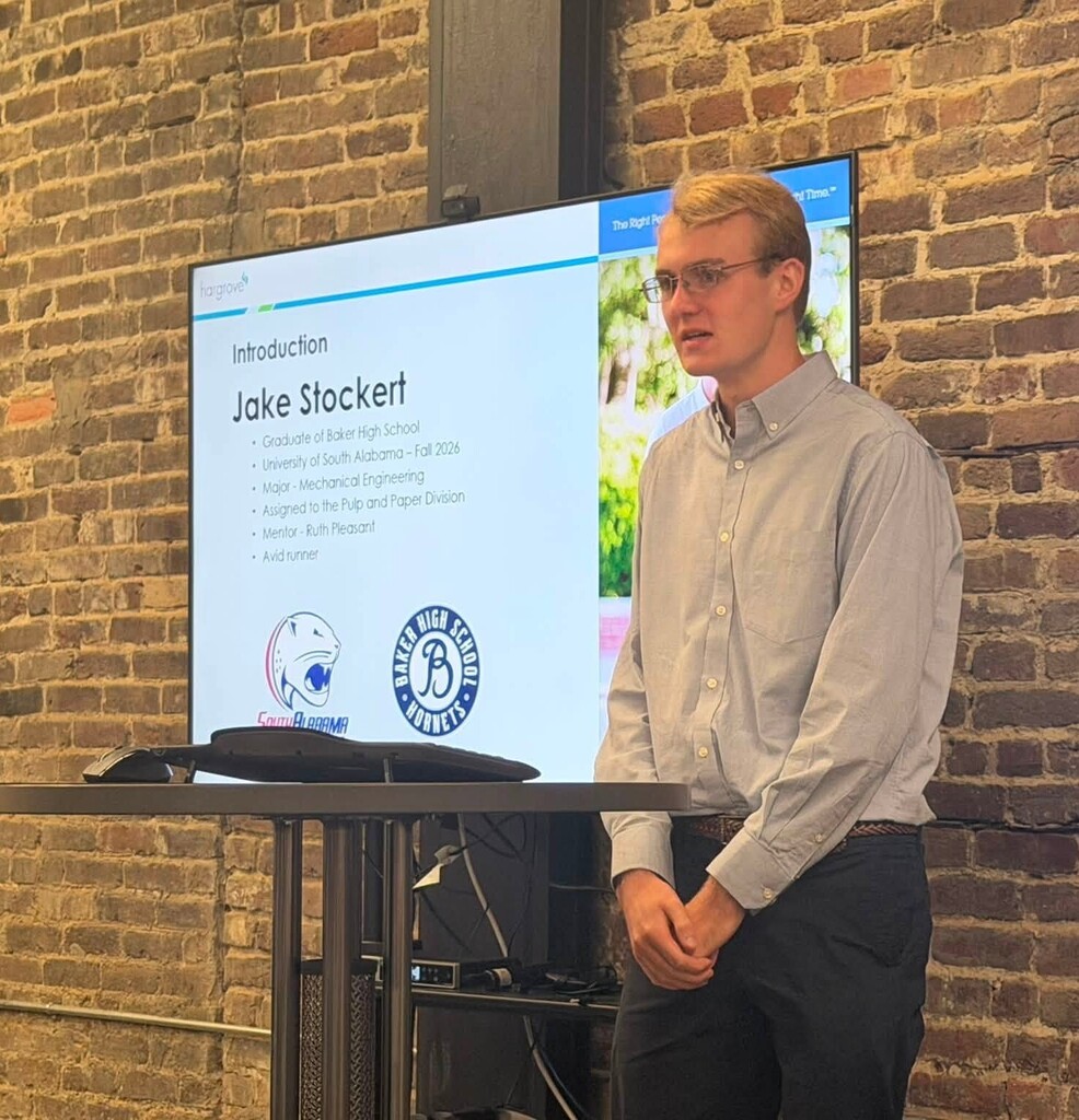 A high school student standing at a podium in front of a smartboard 