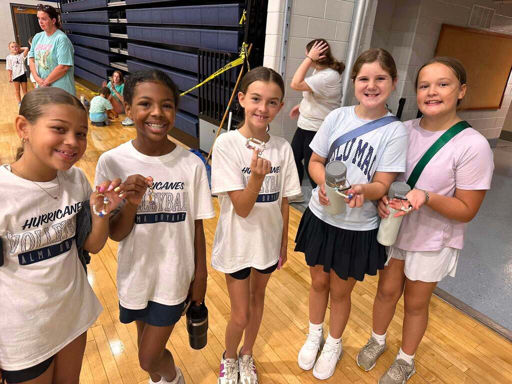 Five elementary girls holding bracelets