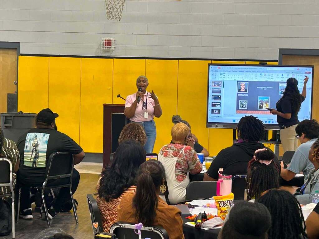 A teacher speaking in front of a room full of other teachers