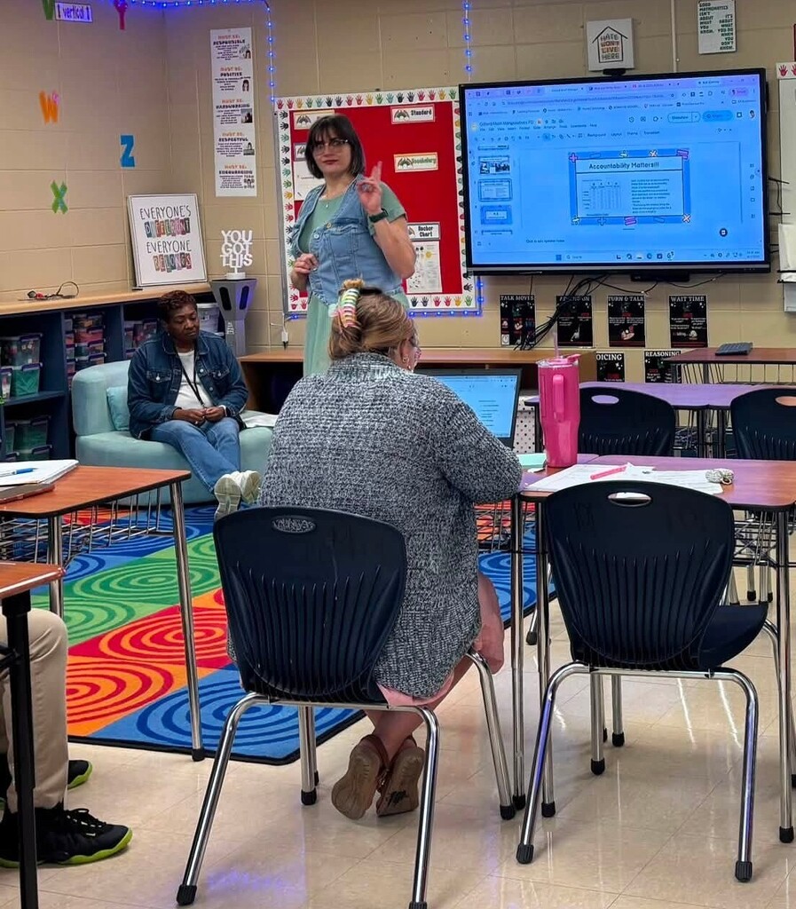 A teacher speaking in a room of other teachers