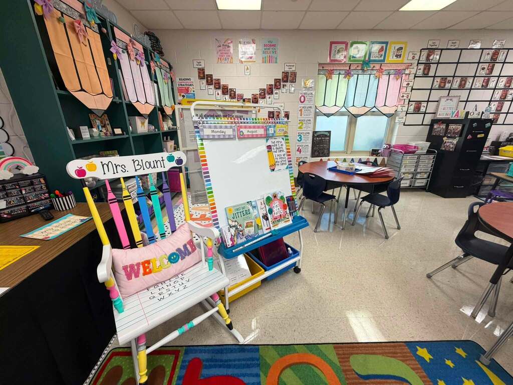 A classroom with a rocking chair bearing the words "Mrs. Blount" and a pillow with the word "welcome"