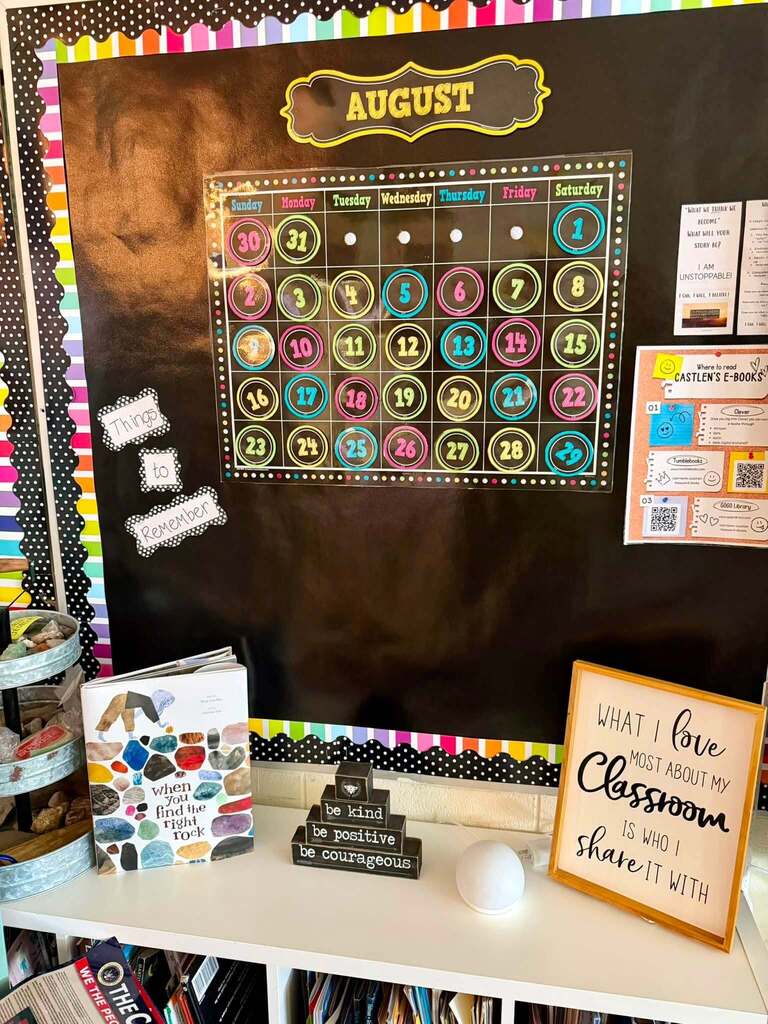 A bulletin board with an August calendar and a sign that reads "What I love most about my classroom is who I share it with"